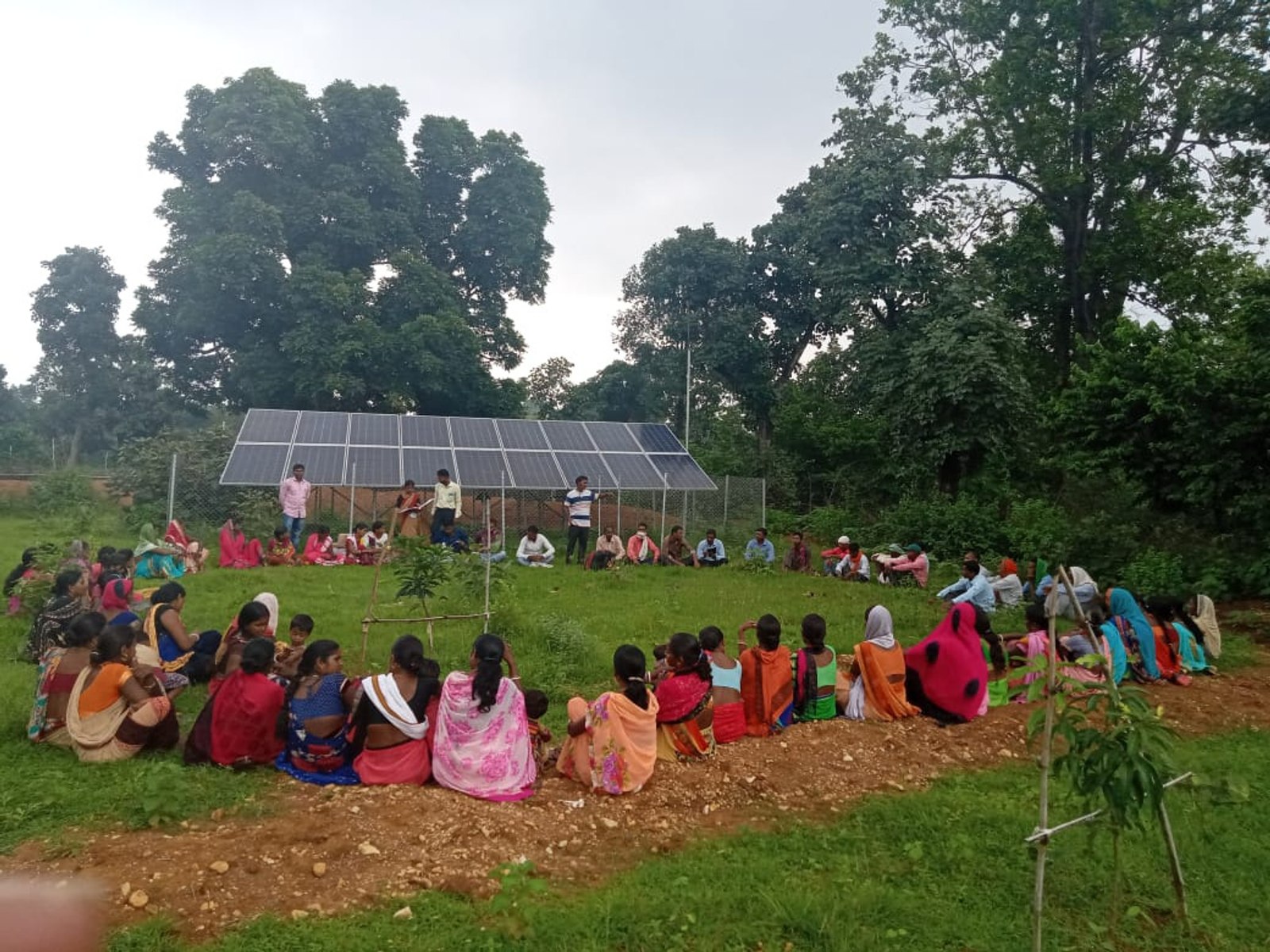 Villagers gathered for a community meeting beside their solar-powered pump installation